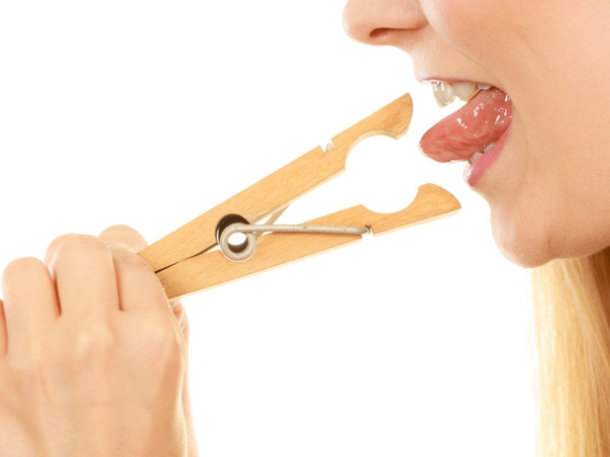 Blonde woman having tongue in clothespin